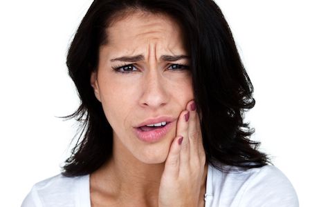 woman holding her mouth due to tooth pain