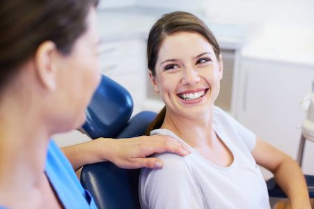 patient speaking with dentist before getting her teeth cleaned